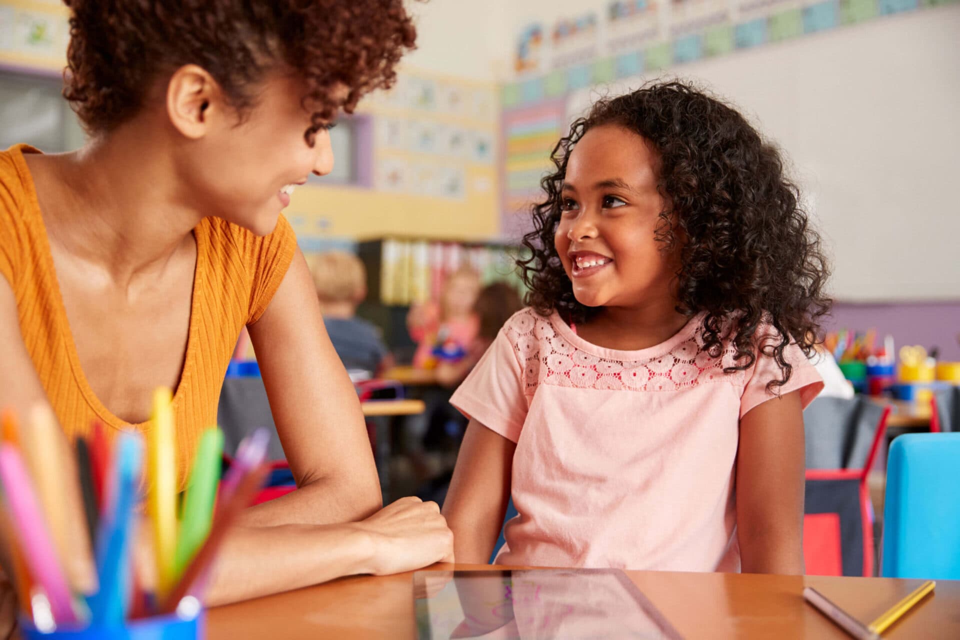 A teacher and a child smiling at each other in a Peyton’s Learning Place classroom